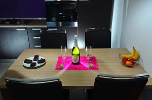una mesa con una botella de vino y dos copas en Apartman Maksimir with free parking en Zagreb