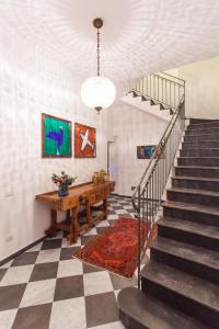 Habitación con escalera, mesa y alfombra. en Guascone Apartments, en Palermo