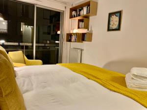 a bedroom with a bed with a yellow blanket on it at Central Montparnasse / Voyage d'affaire / Découverte de la ville in Paris