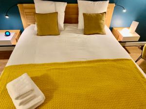 a large bed with a yellow blanket on it at Central Montparnasse / Voyage d'affaire / Découverte de la ville in Paris