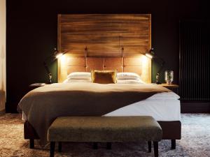 a bedroom with a large bed with a wooden headboard at Gastwerk Hotel Hamburg in Hamburg