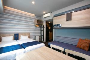 una habitación de hotel con 2 camas y un banco en Minn Nishi-Kasai, en Tokio