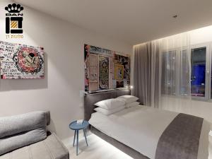 una camera da letto bianca con un letto e un divano di Link Hotel & Hub By Dan Hotels a Tel Aviv