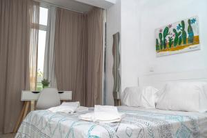 a white bedroom with a bed and a window at La Moraga de Poniente Malaga Hostel in Málaga