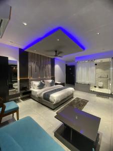 a large bedroom with a bed and a blue lighting at HOTEL CROWN PALACE in Surat