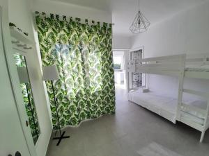 una camera con letto a castello e tenda verde di Otranto Casetta del Turchese a Otranto