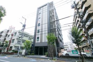 un edificio alto de cristal en una calle de la ciudad en Minn Nishi-Kasai en Tokio