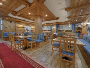 a dining room with wooden tables and blue chairs at Chalet Degli Angeli in Folgarida