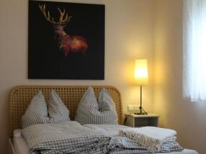 - une chambre avec un lit orné d'une peinture murale sur cerfs dans l'établissement Lautertal Zinne, à Hayingen