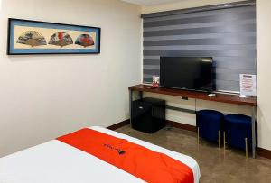 une chambre d'hôtel avec un lit et une télévision dans l'établissement RedDoorz Plus @ Toshiko Boutique Hotel Koronadal City, à Koronadal