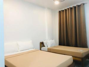 a room with two beds and a curtain at WILDROSE INN in El Nido