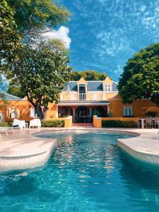 a house with a swimming pool in front of a house at Sirena Bay Estate in Willemstad