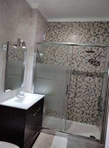 un bagno con doccia, lavandino e doccia di A Casa da Nocas a Setúbal Altre 18 foto