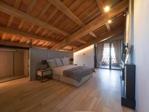 1 dormitorio con 1 cama y suelo de madera en Relais Colle Messino Briaglia Mondovì, en Mondovì
