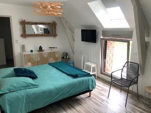 ein Schlafzimmer mit einem Bett, einem Stuhl und einem Fenster in der Unterkunft Le Cellier - Domaine des Haies in Dol-de-Bretagne