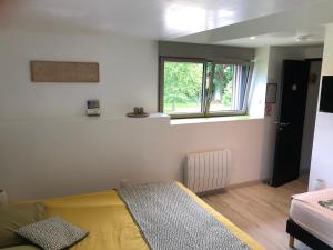 ein Schlafzimmer mit einem Bett und einem Fenster in der Unterkunft Le Cellier - Domaine des Haies in Dol-de-Bretagne + 4 Fotos