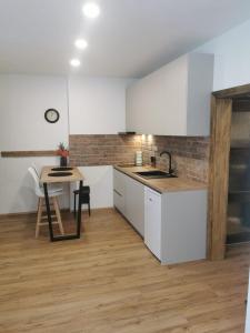 een keuken met witte kasten en een tafel en een aanrecht bij Apartmán Bart's in Znojmo