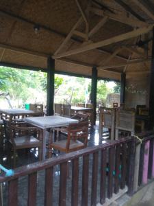 a wooden deck with tables and chairs on a porch at Family bungalow in Gili Meno