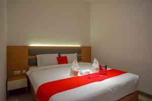 ein Schlafzimmer mit einem großen Bett mit einer roten Decke in der Unterkunft RedDoorz Plus @ Losari Makassar in Makassar