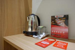 eine Kaffeekanne auf einem Tisch mit einer Schachtel in der Unterkunft RedDoorz Plus @ Losari Makassar in Makassar + 22 Fotos