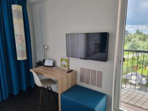 a room with a desk with a tv and a window at Grimm's Potsdamer Platz in Berlin