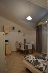 a kitchen and dining room with a table and chairs at Apartmani Katarina in Brodarica