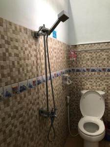 a bathroom with a shower with a toilet in it at Inalum Permata Guest House 