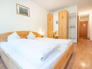 a bedroom with a large white bed with a wooden headboard at Beautiful Apartment in Stubaital in a quiet location in Neustift im Stubaital