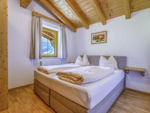 a bedroom with a bed with white sheets and a window at Wonderful Apartment in Stubaital with Ski Boot Heaters in Neustift im Stubaital