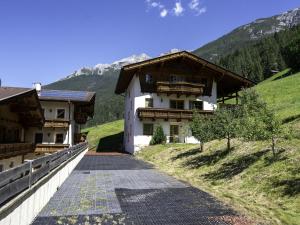 a building on a hill next to a mountain at Wonderful Apartment in Stubaital with Ski Boot Heaters in Neustift im Stubaital