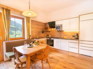 a kitchen with a wooden table and a dining room at Amazing Apartment in Neustift im Stubaital near Ski Lift in Neustift im Stubaital