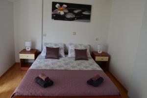 a bedroom with a large bed with two night stands at Apartmani Katarina in Brodarica