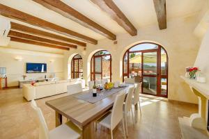 a dining room with a table and white chairs at Tfiefa Holiday Home in Xagħra