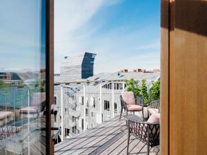 d'un balcon avec une chaise et une vue sur la ville. dans l'établissement Fully serviced apartment with spectacular views towards the Munch Museum, à Oslo