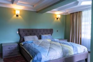 a bedroom with a bed with blue walls and a window at Alphas Homestay in Naivasha