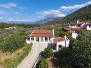 une vue aérienne sur une maison blanche avec un toit rouge dans l'établissement AnaMar Eternity House, à Asprókambos