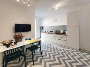 a kitchen with a table and two chairs and a tv at La Casa di Mina in Monte di Procida