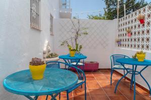 マラガにあるLa Moraga de Poniente Malaga Hostelの- パティオ(青いテーブル2台、椅子付)