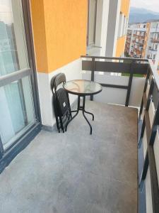 einen Balkon mit einem Tisch und 2 Stühlen darauf in der Unterkunft Grandis Residence in Braşov