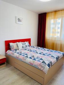 ein Schlafzimmer mit einem Bett mit einer Steppdecke darauf in der Unterkunft Grandis Residence in Braşov