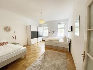 een slaapkamer met 2 bedden en een tapijt bij Sunny Apartment near Belvédère Castle in Wenen