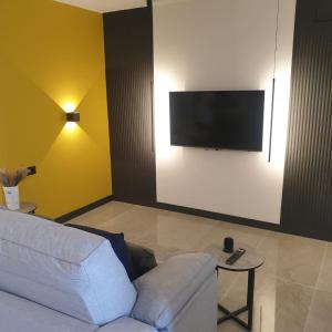 a living room with a white couch and a flat screen tv at Urbanlux Olimpia Familiar in Albacete