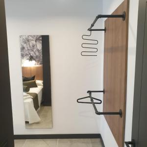 a room with a white wall with a mirror at Urbanlux Olimpia Familiar in Albacete