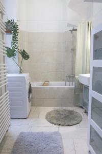 a bathroom with a tub and a toilet and a sink at Sunny Apartment near Belvedere Castle in Vienna +8 photos