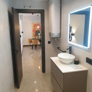 a bathroom with a sink and a mirror at Urbanlux Olimpia Familiar in Albacete