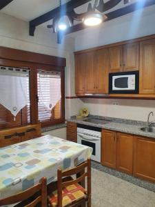 a kitchen with a table and a microwave at Casa Celedonio in Cerredo