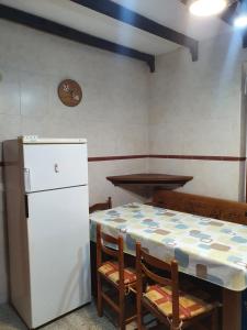 uma cozinha com uma mesa e um frigorífico branco em Casa Celedonio em Cerredo