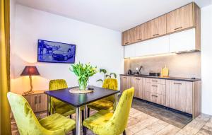cocina y comedor con mesa y sillas amarillas en Nice Apartment In Wladyslawowo With Wifi, en Władysławowo