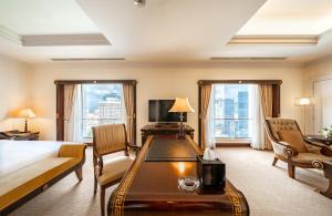 ホーチミン・シティにあるLotte Hotel Saigonのベッドとデスクが備わるホテルルームです。