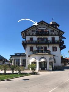 een groot wit gebouw met balkons in een straat bij Ferienwohnung Inselblick in Schliersee